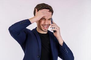 portret van moe knap zakenman pratend door mobiel telefoon en houden hand- naar hoofd geïsoleerd over- wit achtergrond foto
