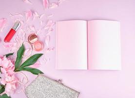 Open notitieboekje met blanco roze Pagina's, boeket van pioenen foto