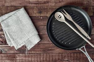 rooster pan en houten keukengerei Aan een bruin houten oppervlakte foto