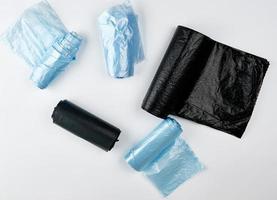 zwart en blauw plastic Tassen voor uitschot kan Aan een wit achtergrond foto