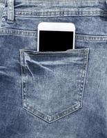 wit smartphone in de terug zak- van blauw jeans foto