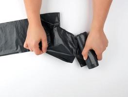 vrouw handen scheur uit een zwart zak voor een bak van een rollen foto