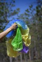 een vrouw hand- houdt een stapel van leeg transparant verfrommeld plastic Tassen voor vuilnis foto