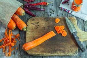 gesneden geschild wortels Aan een keuken snijdend bord foto