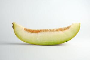stuk van rijp meloen met zaden Aan een wit achtergrond foto