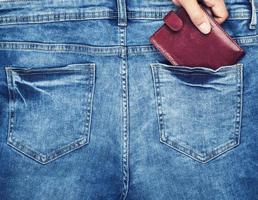 bruin leer handtas leugens in de terug zak- van blauw jeans foto