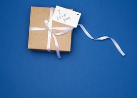 bruin geschenk doos met wit boog en wit papier bedrijf kaart foto