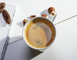 wit keramisch mok met zwart koffie en schuim foto