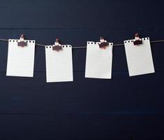 leeg wit notitieboekje papier lakens hangende Aan decoratief vakantie wasknijpers foto