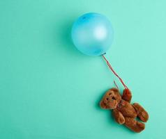 weinig bruin teddy beer Holding een roze opgeblazen ballon foto