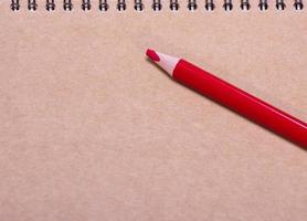 rood houten potlood Aan een bruin vel van papier foto