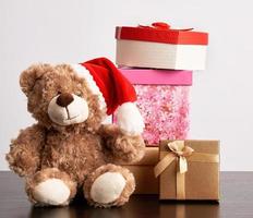 bruin teddy beer en een stack van divers karton dozen voor cadeaus foto