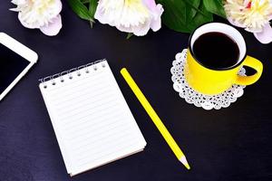 leeg notitieboekje en geel kop met koffie foto