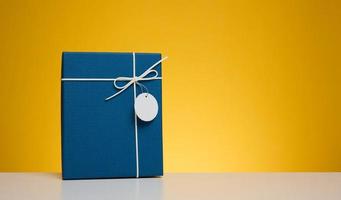 blauw karton geschenk doos Aan geel achtergrond foto