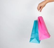 vrouw hand- Holding gekleurde papier boodschappen doen verpakking Tassen foto