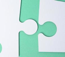 wit papier puzzels Aan een groen achtergrond, verbinding foto