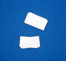stack van blanco rechthoekig papier wit bedrijf kaarten Aan een blauw achtergrond foto