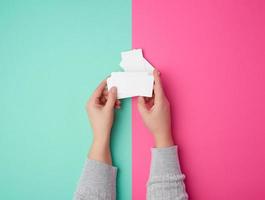 twee vrouw handen Holding een stack van leeg wit papier bedrijf kaarten foto