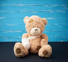 bruin teddy beer met teruggespoeld wit verband poot foto