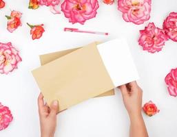 twee vrouw handen houden een bruin papier envelop foto