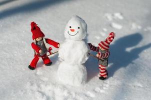 twee speelgoed- weinig Mens gemaakt van een sneeuwman sneeuw foto