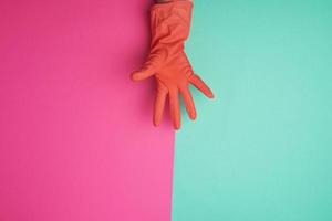 rubber oranje handschoen voor schoonmaak de huis gekleed Aan een vrouw hand- foto