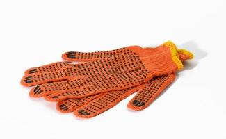 textiel oranje werk handschoenen Aan een wit achtergrond. beschermend kleding voor handleiding arbeiders foto