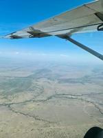 visie van een vliegtuig op de vleugel en de savanne in Kenia onderstaand. foto
