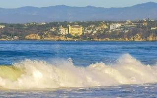 extreem reusachtig groot surfer golven Bij strand puerto escondido Mexico. foto