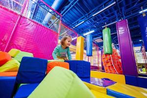 baby meisje spelen Bij binnen- Speel centrum speelplaats. foto