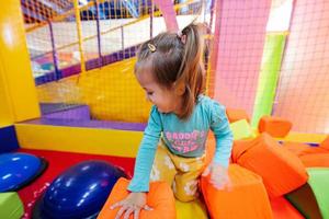 baby meisje spelen Bij binnen- Speel centrum speelplaats. foto