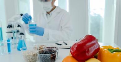 wetenschapper controleren chemisch voedsel residuen in laboratorium. controle experts inspecteren kwaliteit van fruit, groenten. laboratorium, gevaren, rohs, vind verboden stoffen, besmetten, microscoop, microbioloog foto