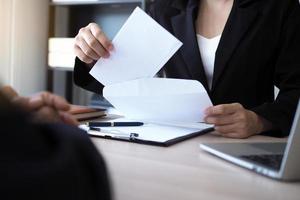 de leidinggevenden zijn opening de envelop van ontslag van de personeel. ontslag van baan standen en vacatures concept foto