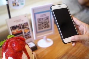 hand- gebruik de telefoon naar scannen de streepjescode naar krijgen de korting in de cafe winkel foto