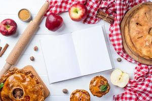 blanco geopend Koken boek mockup met appel taart, vlees taart en seizoensgebonden fruit foto