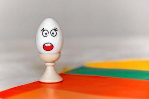Aan gekleurde papier, een staan met een wit ei, Aan welke Daar is een sticker met de emotie van verrassing, schrik, minimalisme, kopiëren ruimte. communicatie Aan de internet gebruik makend van emoticons met emoties foto