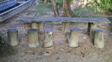 tuin meubilair gemaakt van hout, houten tafel en houten log natuurlijk stoel of oppas. foto