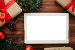 vrolijk kerstfeest tabletcomputer mockup-sjabloon met decoraties van dennenbladeren foto