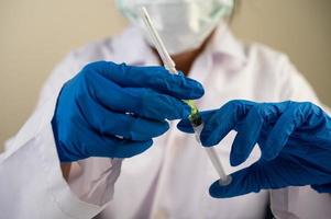 wetenschappers die maskers dragen en handschoenen die een spuit met een covid-19-vaccin vasthouden
