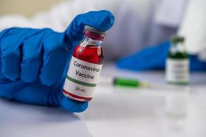 wetenschapper die flesjes met vaccins toont ter bescherming tegen covid-19