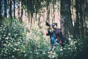 jonge fotograaf die foto's maakt in het bos foto