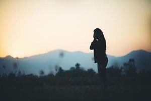 silhouet van vrouw over prachtige zonsondergang achtergrond foto