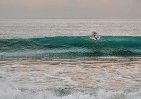 persoon die op zeegolven surft foto