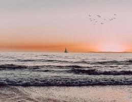 silhouet van zeilboot op zee tijdens zonsondergang foto