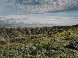 groen grasveld onder witte wolken overdag foto