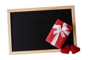 rood geschenk doos en rood hart vorm Aan de zwart bord geïsoleerd Aan wit achtergrond. foto