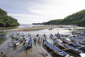 baron strand in Gunung kidul, Indonesië met bezoeker en traditioneel boot. yogakarta, Indonesië - januari, 2023. foto