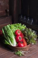 gezond voedsel groente rood sla en romaine tomaat wortel in mand Aan hout tafel, top visie, kopiëren ruimte. foto