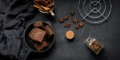 stukken van gebakken brownie in een metaal zwart frituren pan Aan de tafel, top visie foto