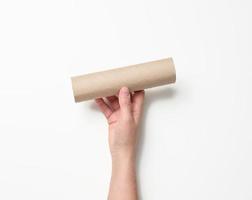 vrouw hand- houdt een papier buis van onder gebruikt servetten Aan een wit achtergrond foto